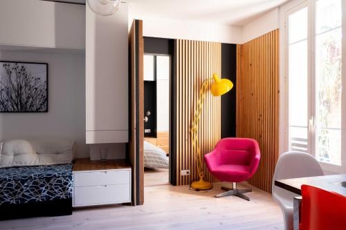 a bedroom with a pink chair and a bed at Modern appartment in the heart of Cap d'Antibes in Antibes