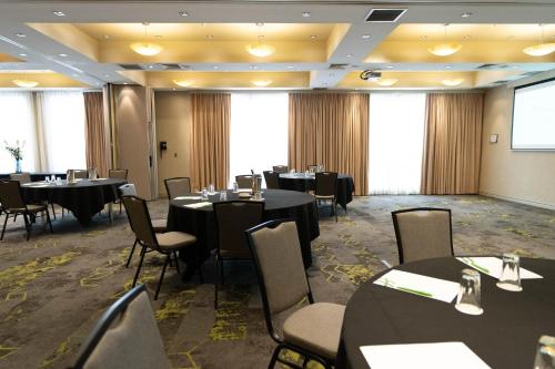 a conference room with tables and chairs and a projection screen at Holiday Inn Parramatta by IHG in Sydney