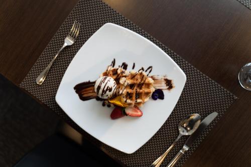 a white plate with a dessert on a table at Holiday Inn Parramatta by IHG in Sydney