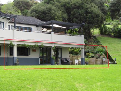 a house with a large yard in front of it at Cornwallis Palms in Auckland