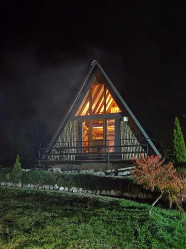 a cabin with a large window at night at Razele Trascaului in Rîmeţi