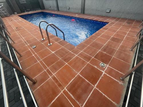an indoor pool with orange tile floors and a pooliterator at Romel Terraces in Lagos