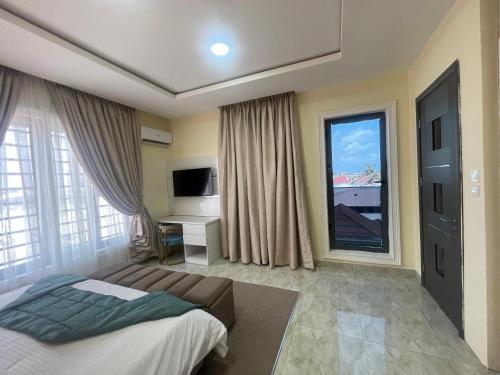 a bedroom with a bed and a large window at Romel Terraces in Lagos