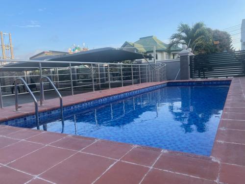 a swimming pool with an umbrella next to a house at Romel Terraces in Lagos