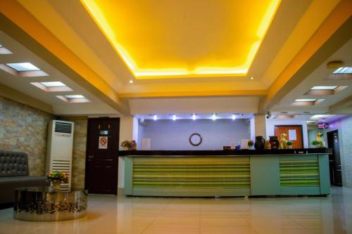 un vestíbulo con un mostrador con techo amarillo en Visiting Card Hotel & Resort, en Bangkok