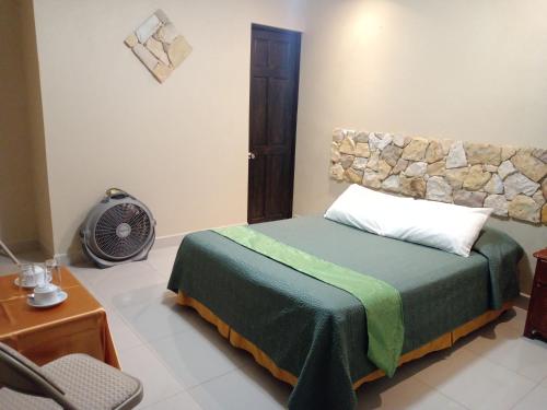 a bedroom with a bed in a room with a fan at Hotel Cibeles Resort in Heredia