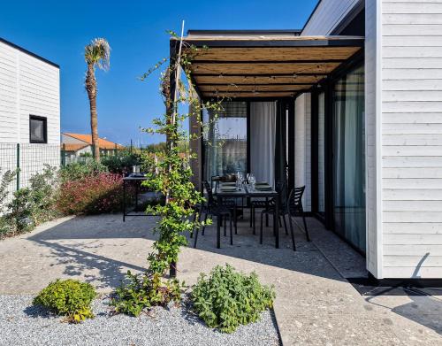 a pergola with a table and chairs on a patio at Ortosalato Agricamping in Torregrotta