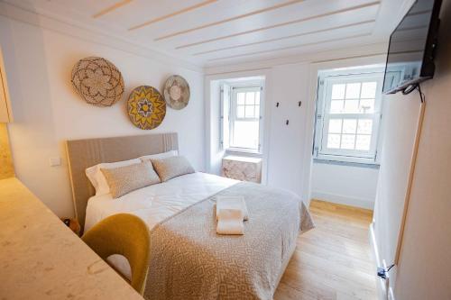 een kleine slaapkamer met een bed en een televisie bij New Lisbon Center Apartment in Lissabon