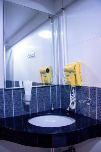 a bathroom with a sink and a mirror at Visiting Card Hotel & Resort in Bangkok