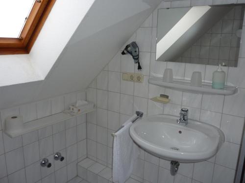 a white bathroom with a sink and a mirror at Hotel Ockenheim in Ockenheim