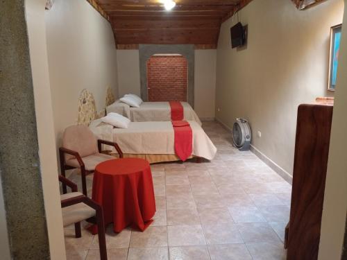 a bedroom with a bed and a table in a room at Hotel Cibeles Resort in Heredia