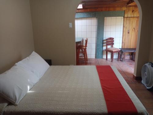 a bedroom with a bed and a dining room at Hotel Cibeles Resort in Heredia
