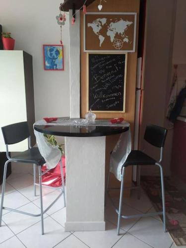 a table and chairs in a room with a chalkboard at Nido delle meraviglie in Canelli