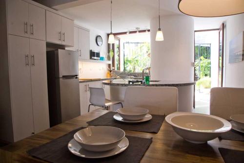 a kitchen with a wooden table with bowls on it at CABARETE BEACH HOUSES the NANNY ESTATES in Cabarete