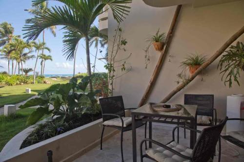 a patio with a table and chairs and a view of the ocean at CABARETE BEACH HOUSES the NANNY ESTATES in Cabarete