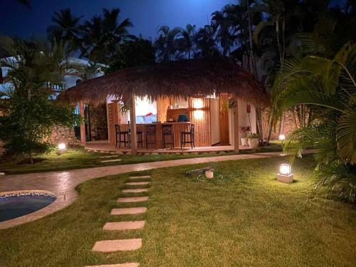 a house with a thatch roof and a yard at CABARETE BEACH HOUSES the NANNY ESTATES in Cabarete