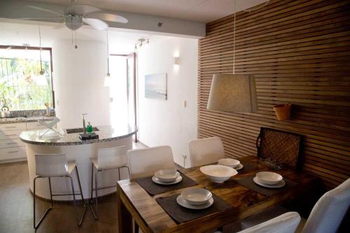 a dining room with a wooden table and white chairs at CABARETE BEACH HOUSES the NANNY ESTATES in Cabarete