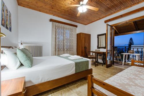 1 Schlafzimmer mit einem Bett und einem Balkon mit einem Tisch in der Unterkunft Evelina's House in Platanias