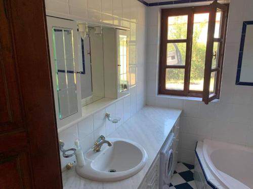 La salle de bains blanche est pourvue d'un lavabo et d'un miroir. dans l'établissement Dorono House, à Balatonudvari