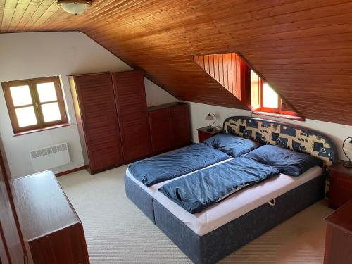 uma cama num quarto com tecto em madeira em Dorono House em Balatonudvari