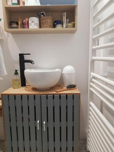 - Baño con lavabo encima de una mesa en Chaumière avec sa toiture recouverte de chaume !!!, en Donnemain-Saint-Mamès