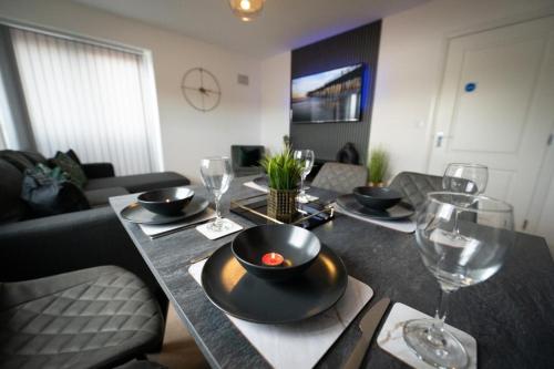 a dining room table with a black bowl and wine glasses at Grand Station Suite in Wolverhampton