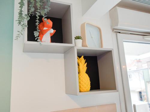 a white shelf with a pineapple on it at ☆ L'Exotique ☆ 2 chambres ☆ NETFLIX ☆ in Metz