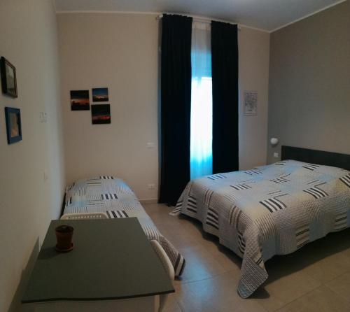 a bedroom with two beds and a table and a window at A casa da Cri B&B in Rome