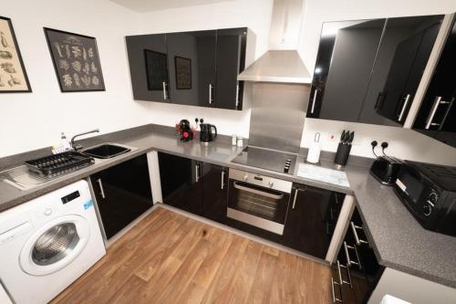 a kitchen with a washer and a stove top oven at Grand Station Suite in Wolverhampton