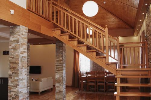 a wooden staircase in a living room with a stone pillar at My sweet home Jahorina in Jahorina