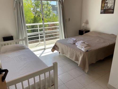 Un dormitorio con dos camas y una gran ventana. en Apart Nivel Cero, en Monte Hermoso