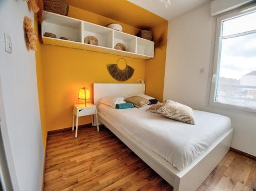a bedroom with a bed and a yellow wall at ☆ L'Exotique ☆ 2 chambres ☆ NETFLIX ☆ in Metz