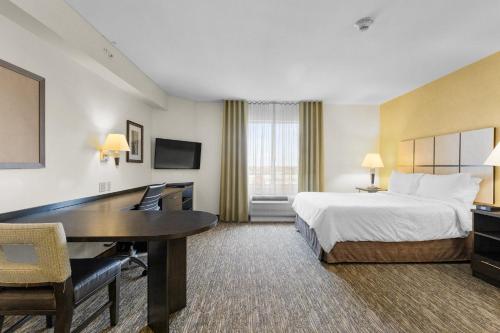 a hotel room with a bed and a desk at Candlewood Suites Erie by IHG in Erie