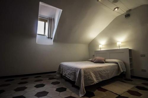 um quarto com uma cama num quarto com uma janela em Casa Gaia em Albissola Marina