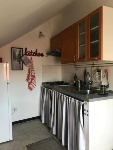 uma cozinha com um lavatório e um fogão em Casa Gaia em Albissola Marina