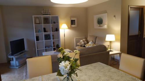 uma sala de estar com um sofá e uma mesa com flores em Playa de Santa Marina - Ribadesella em Ribadesella