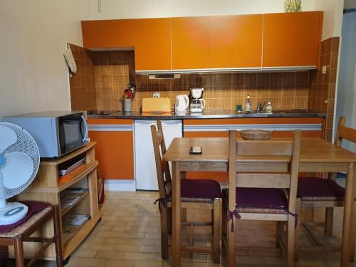 een kleine keuken met een tafel en een magnetron bij Studio avec balcon vue sur le Tech in Amélie-les-Bains-Palalda