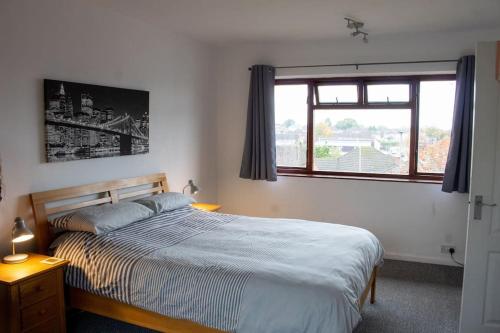 a bedroom with a bed and a window at Mickleover House-Large Detatched Family House in Derby