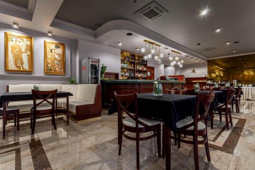a restaurant with tables and chairs and a bar at Hotel Poniatowski in Radom