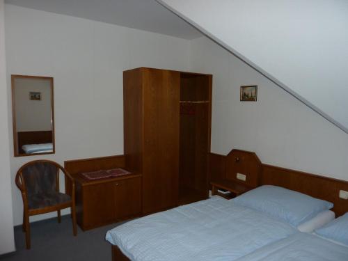 a bedroom with a bed and a desk with a chair at Hotel Ockenheim in Ockenheim