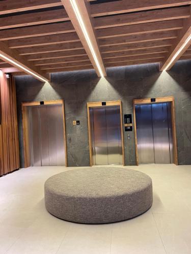a room with three elevators and a circular rug at Apartman Kopaonik Woodside 106 in Kopaonik