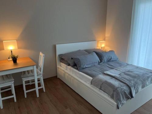 1 dormitorio con 1 cama y escritorio con 2 lámparas en Ferienwohnung Emperors Baths - Cozy Modern Studio Apartments, en Trier