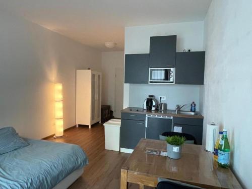 Habitación con cama y cocina con mesa en Ferienwohnung Emperors Baths - Cozy Modern Studio Apartments, en Trier