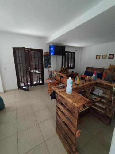 a large room with wooden tables and a television at Hostel Ares do Mundo in Miguel Pereira