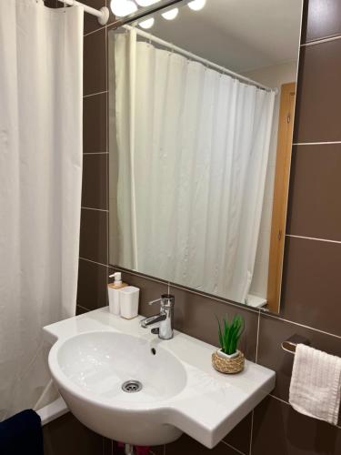 a bathroom with a white sink and a mirror at Fantastic apartment a few meters from the beach in the center of Estartit in L'Estartit