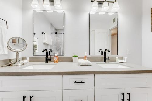 - une salle de bains blanche avec deux lavabos et deux miroirs dans l'établissement Modern Desert, à Tempe