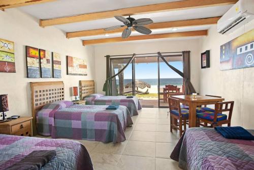 Cette chambre comprend 4 lits, une table et une fenêtre. dans l'établissement Punta Conejo Resort, à Salina Cruz