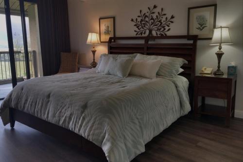 a bedroom with a large bed with two lamps and a phone at Hanalei Bay Resort 8233 in Princeville