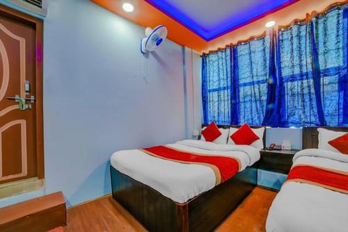 - une chambre avec 2 lits et des oreillers rouges dans l'établissement Guru hotel and lodge, à Itahari