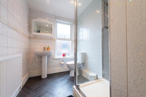 a bathroom with a toilet and a sink and a shower at Chestnut Heritage,- Large & Cheerful 5 bedroom house with free parking in Liverpool